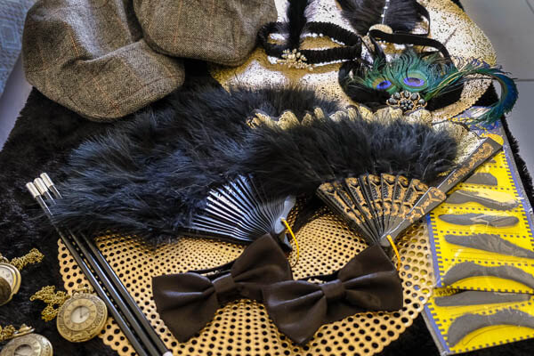 Gatsby styled props, moustache, cigarett holder, feather fans, po bo hats, head dress, and pocket watch