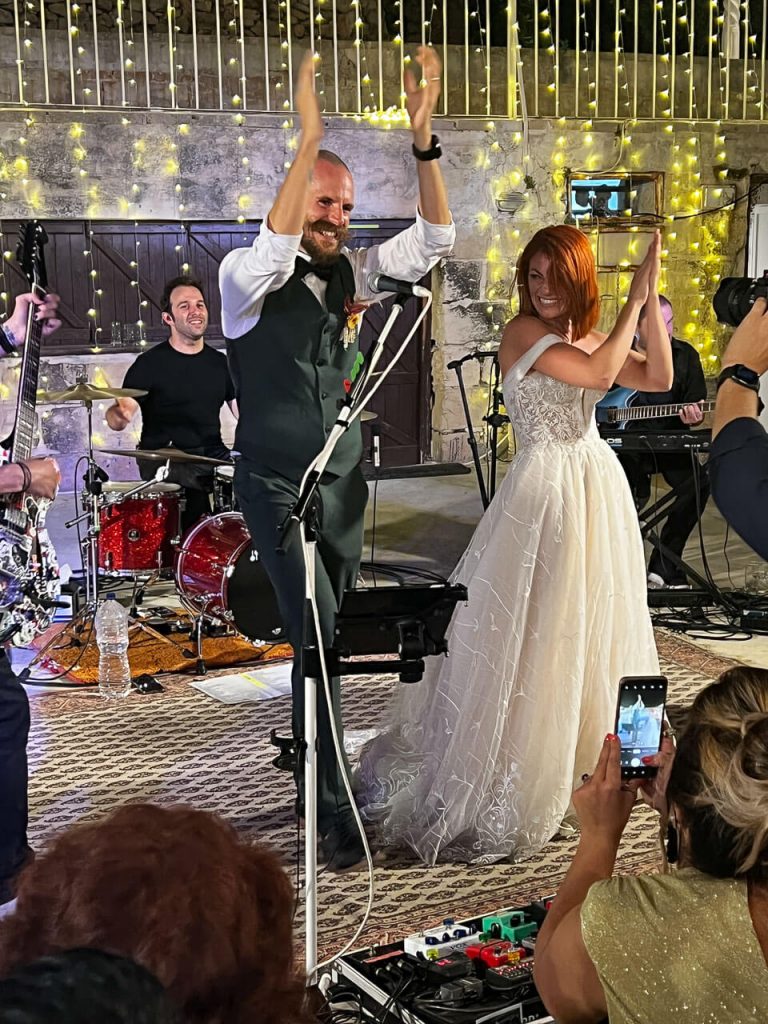 bride and groom singing on stage with the band