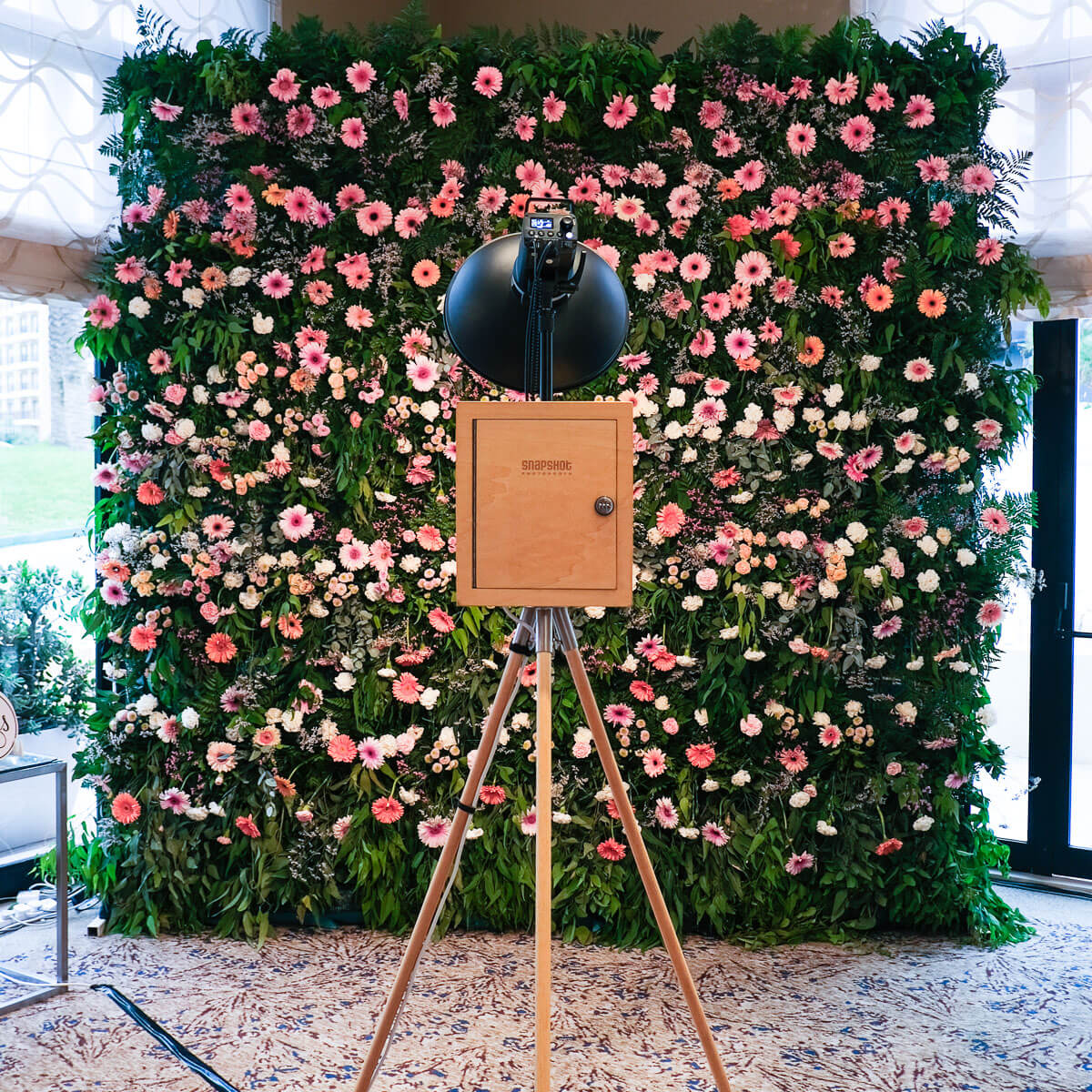 A stunning live flower wall with a vintage style photo booth