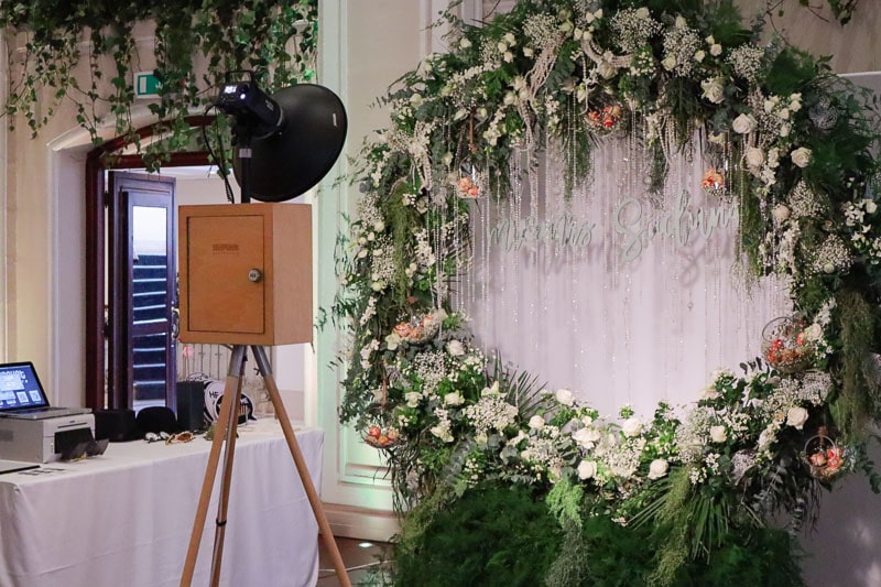 A vintage photo booth and a flower arch backdrop