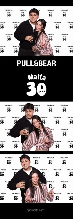 pull-and-bear-malta-30th-anniversary-guests-photo-strip-3 Photo strip of a young couple posing closely together, smiling and making peace signs in front of the branded backdrop.