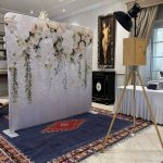 A photo booth in front of a backdrop.