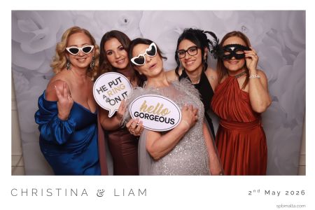 bridesmaids-and-friends-photo-booth-fun Bridesmaids and friends wearing heart-shaped sunglasses and props for a group photo.