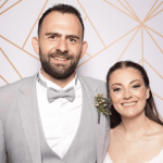 Hero image of newlyweds Jeremy and Luisa taking a photo on their wedding day.