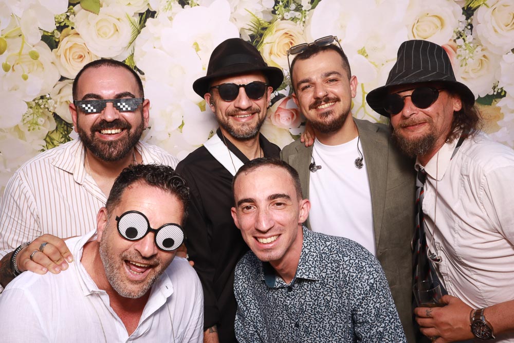 wedding-photo-booth-malta-group-of-friends Group of friends smiling and taking a memorable photo during a wedding celebration.